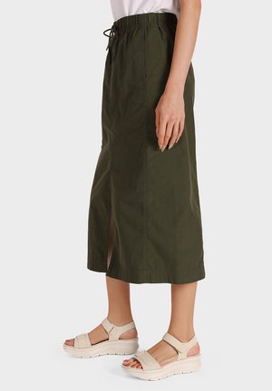 Gonna midi verde oliva in tessuto leggero, con vita regolabile e spacchi laterali, abbinata a sandali con zeppa beige.