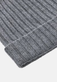 Pilkas juostelėmis mezgamas šalikas su minkštu, tekstūriniu paviršiumi ir sulankstytu kraštu. Turi pastovų raštą visame paviršiuje.