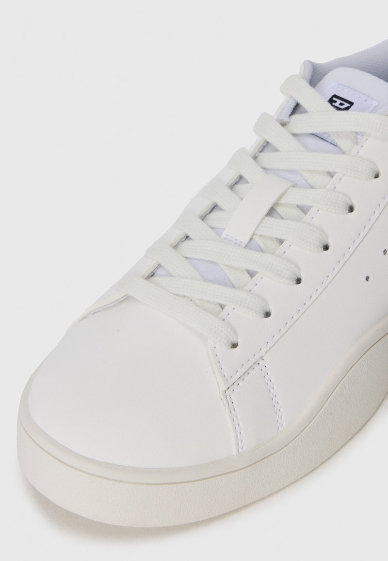 Zapatilla blanca con parte superior de cuero liso, puntera redonda, cordones planos y diseño minimalista con costuras ligeras y suela de goma.