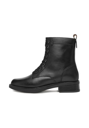 Botín de cuero negro hasta el tobillo con cordones en la parte frontal, tirador en la parte posterior, tacón bajo y acabado suave sobre un fondo blanco.