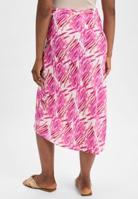 Maxiröcke mit einem rosa und weißen abstrakten Muster, elastischem Bund und einem glatten, leichten Stoff. Der Saum hat einen leicht asymmetrischen Schnitt.