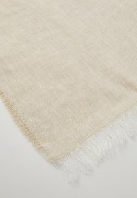 Linnedug i off-white med en tekstureret overflade; kanterne har løse, frynset tråde, hvilket giver en naturel finish.