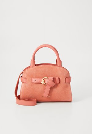 Sac à main en velours corail avec une forme structurée, deux poignées et une bandoulière amovible. Présente un détail en nœud et des finitions en métal doré.