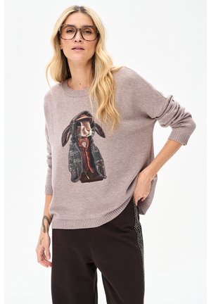 Lichtpaarse gebreide trui met een konijnenafbeelding in een jas met gedetailleerde borduursels. Het ontwerp heeft een losse pasvorm en geribbelde manchetten.
