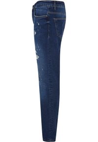 Jeans de mezclilla azul oscuro con un corte ajustado, que presentan áreas desgastadas y sutiles arrugas. La tela tiene una textura suave con un ligero estiramiento.