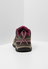 Braune und rosa wasserdichte Wanderschuhe mit strukturiertem Obermaterial, gepolstertem Kragen und Gummisohle. Reflektierende Akzente und Logo sichtbar.