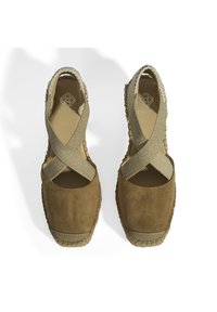 Braune Wildleder-ESPADRILLES mit einem Kreuzriemendesign, elastischem Band und gewebten Juteböden. Glatte Textur mit minimalistischem Stil.