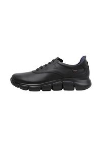 Zapatilla deportiva de cuero negro con un empeine suave, puntera redondeada y suela segmentada distintiva. Cuenta con cordones y un sutil logotipo en el lateral.