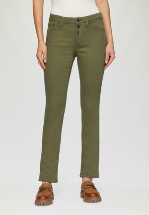 Straight-cut olive green pants with front button closure worn with brown loafers and a white top, shown from waist to feet.