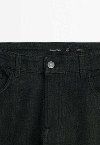 Jeans neri slim fit in denim, con chiusura con bottone argentato, passanti per cintura e etichetta con il marchio "Massimo Dutti".