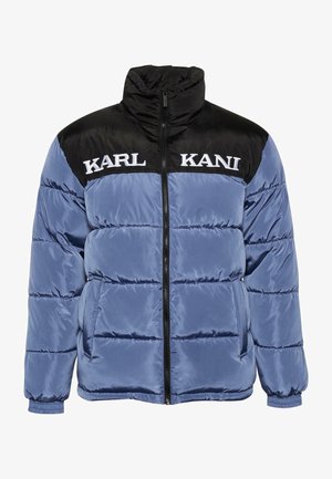 Pufasta jakna u svijetloplavoj i crnoj boji, s visokim ovratnikom, zatvaranjem na zatvarač, bočnim džepovima i imenom "KARL KANI" u bijeloj boji na prsima.