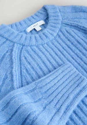 Light blue ribbed sweater with a crew neckline and tag labeled "NEXT," featuring soft texture and slight sheen.