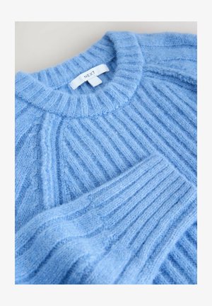 Light blue ribbed sweater with a crew neckline and tag labeled "NEXT," featuring soft texture and slight sheen.