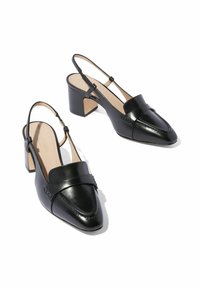 Tacones slingback de cuero negro con punta afilada, tira en el empeine y tacón cuadrado. Textura suave y detalles de costura sutiles.