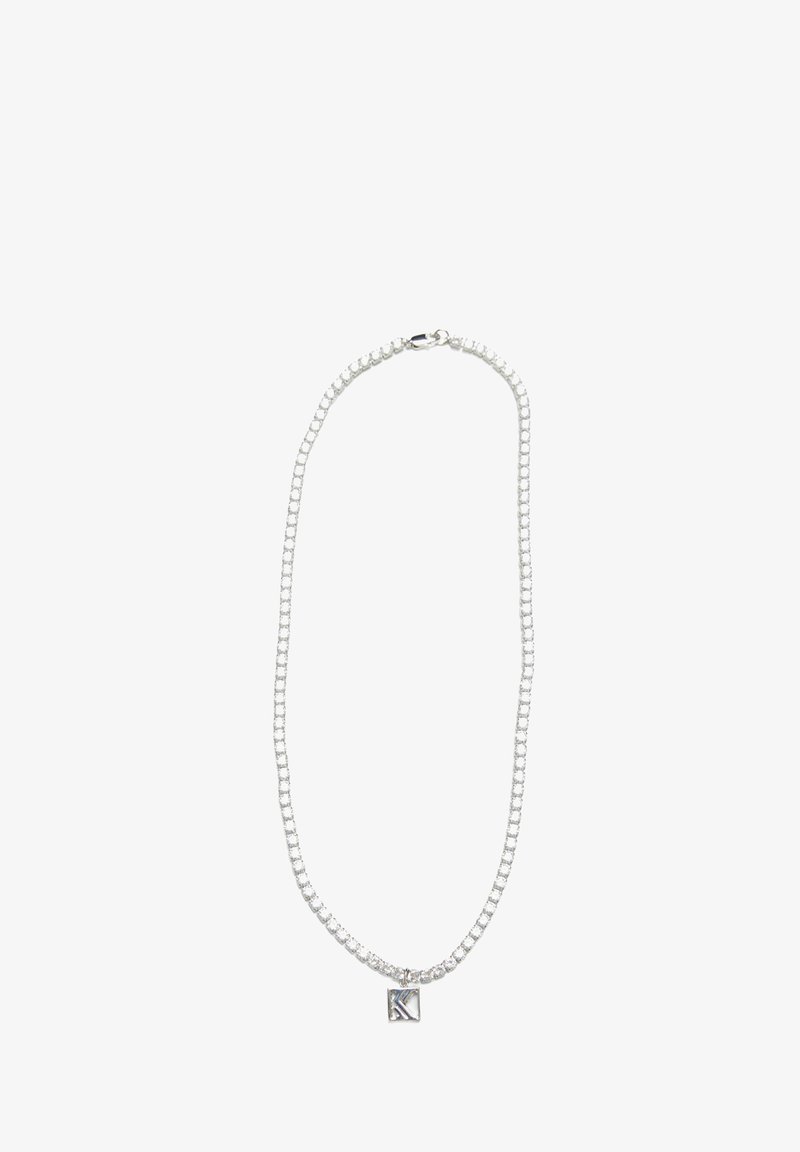 Sølv kædedesign med sammenlåsende led, prydet med en lille firkantet vedhæng, der er indgraveret med bogstavet "K."