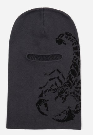 Svart stickad balaklava med ett skorpionmönster på vänster sida, med ögonöppningar och en tight passform för värme.