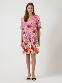 Rosa blommig klänning med korta puffärmar, med flerfärgade blommönster och en v-ringning, tillverkad av lättviktsmaterial.