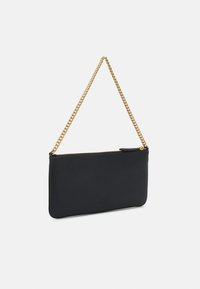 Pochette en cuir noir avec une bandoulière en chaîne dorée. Elle dispose d'une fermeture éclair et d'un logo en relief à l'avant. Design élégant et rectangulaire.