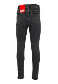 Jean en denim noir slim-fit vu de dos avec deux poches arrières et une étiquette de marque Diesel rouge attachée à la taille.