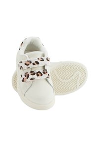 Baskets blanches avec des sangles Velcro à imprimé léopard, en cuir lisse, à bout arrondi, et une semelle en caoutchouc texturée avec un motif ondulé.