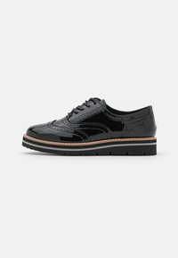 Scarpe in pelle verniciata nera con dettagli brogue, punta rotonda e suola platform bicolore con un accento marrone chiaro e gomma nera testurizzata.