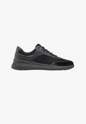 Sneaker nera con tomaia bassa, pannelli in mesh e pelle, chiusura con lacci, collarino imbottito e suola spessa in gomma, vista laterale.