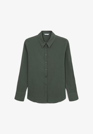 Camicia verde scuro con bottoni, realizzata in tessuto strutturato, caratterizzata da un colletto classico, maniche lunghe e bottoni neri lungo la parte anteriore.