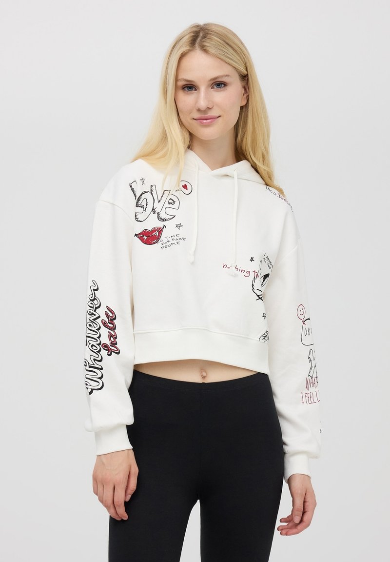 Hoodie bianco corto con grafiche, inclusi labbra, cuori e testo. Maniche lunghe con "Whatever" stampato in nero. Tessuto morbido e texture.