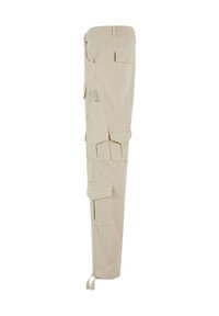 Beige cargo nadrágok több zsebbel, egyenes szabással és cipzárokkal a bokánál. Tartós pamut anyagból készült, sima textúrával.