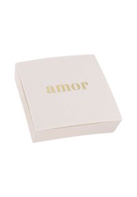 Torgubbe i cremefärgad färg med en slät yta, med ordet "amor" i präglad guldskrivning på locket.