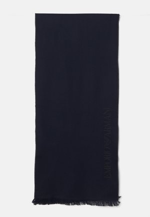 Sciarpa blu navy realizzata in morbido tessuto, con bordo frangiato e dettaglio del logo in rilievo lungo un lato. Forma rettangolare.