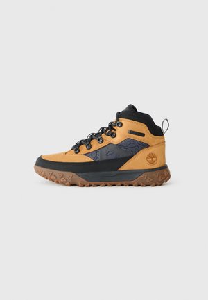 Botas de caminhada em estilo médio, castanhas e pretas, com sola de borracha, parte superior em couro texturizado, detalhes sintéticos e ilhós de metal para os atacadores.