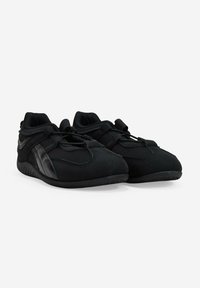 Zapatillas deportivas negras con un upper suave similar al ante, diseño de puntera redondeada y acentos negros mate contrastantes a los lados. Cordones en la parte delantera.