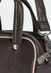 Ciemnobrązowa skórzana torebka z różowymi akcentami, wyposażona w podwójne uchwyty, ozdobne przeszycia oraz srebrny zamek błyskawiczny z zawieszką.