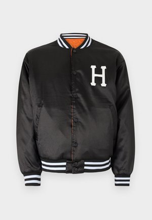 Black satin varsity jacket with white letter "H," snap buttons, and striped ribbed cuffs and hem. Features orange lining and smooth texture.