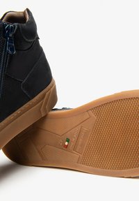 Stivaletti alla caviglia in suede blu navy con zip, dotati di suola in gomma beige con grip texturizzato e dettaglio della bandiera italiana sulla soletta.