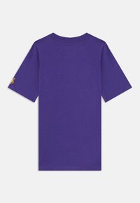 Lilla bomull t-skjorte med korte ermer, rund hals og en liten brodert logo på venstre erme. Glatt tekstur, ledig passform.