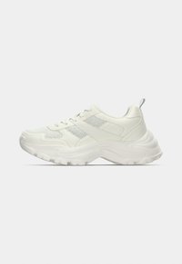 Άσπρο αθλητικό παπούτσι με επάνω μέρος από υφασμάτινο πλέγμα με υφή, επενδεδυμένο κολάρο και παχιά λαστιχένια σόλα· διαθέτει στρογγυλεμένη μύτη και σχεδιασμό με κορδόνια.