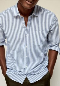 Blue and white striped short-sleeve shirt, button-front, with a chest pocket. Made from a lightweight fabric with a soft texture.