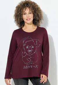 Bordeaux shirt met lange mouwen met een zilveren omtrek van een koala met een Santa-hat, met daaronder "Merry-X" gedrukt. Casual fit.