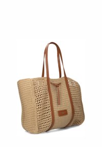 Beige geweven tas met twee lange bruine leren handvatten en een lederen strikdetail aan de voorkant, ruim met een rechthoekige bodem.