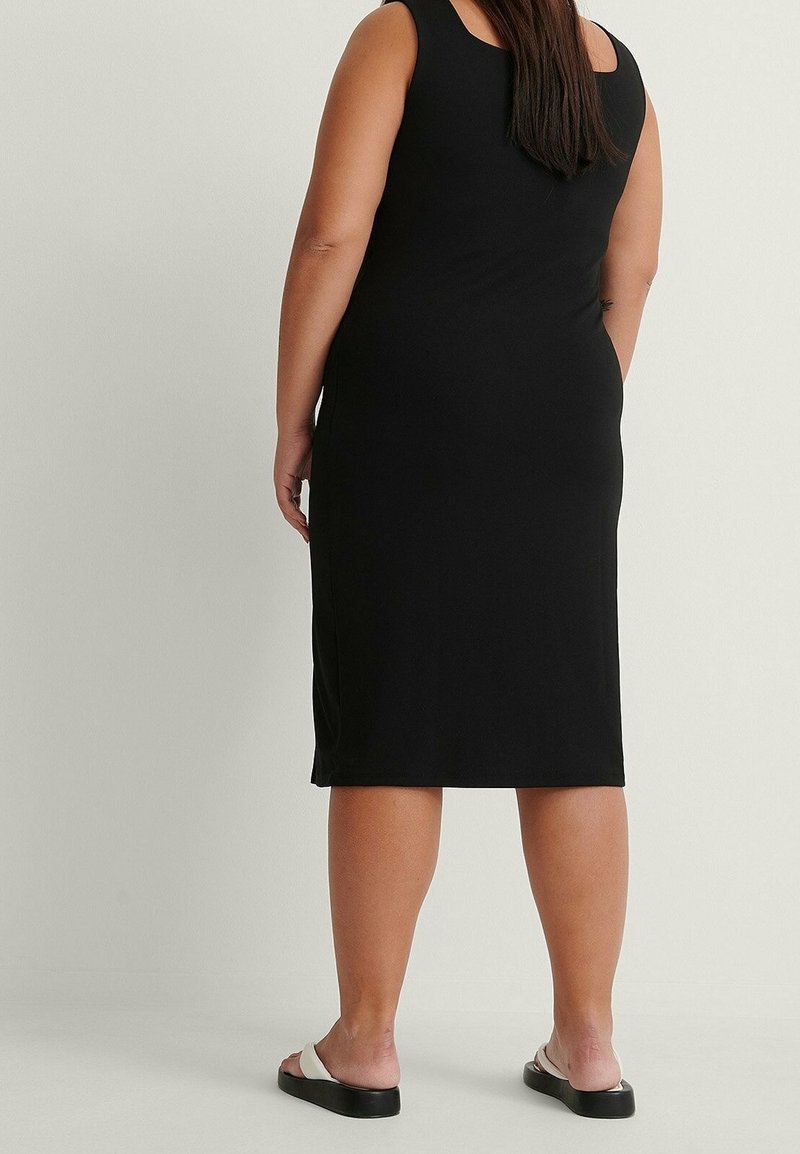 Schwarzes ärmelloses Kleid mit geradem Schnitt, aus weichem, dehnbarem Stoff. Mit rundem Ausschnitt und knielangem Saum.