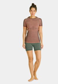 Red and gray fitted short-sleeve shirt with raglan sleeves, paired with green shorts. Smooth texture and athletic design.