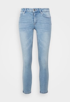 Lyseblå slim fit cowboybukser med frontknap, lynlås, bæltestropper og klassisk fem-lomme-design på en hvid baggrund.