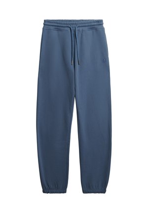 Blaue Jogginghose mit elastischem Bund und Kordelzug, Seitentaschen, elastischen Bündchen und dezentem Logo am linken Oberschenkel.