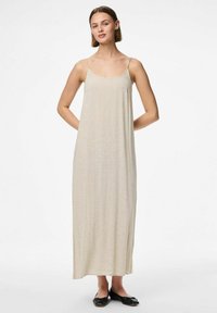 Robe maxi sans manches beige avec fines bretelles, réalisée en tissu texturé, tombe jusqu'aux chevilles, avec une coupe décontractée et un design minimaliste.