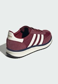 Bordo suede sportska cipela s tri bijele pruge, dizajn spertovanjem i bijelim međuslojem. Ima teksturiranu gumenu potplat.