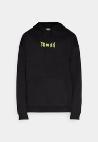 Sudadera negra de tela suave, con un bolsillo canguro y texto gráfico verde vibrante en el pecho. Incluye cordones ajustables.
