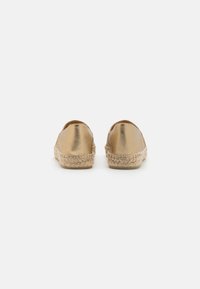 Espadrillas metalliche dorate con suola in juta intrecciata. Il design è slip-on, caratterizzato da una finitura liscia e brillante e una punta arrotondata.