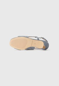 Gray suede sandal featuring a distinctive design with a rounded toe, adjustable strap, and a textured rubber sole.